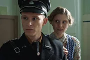 Rudolf Höß (Joel Basman) begegnet später Heinrich Himmler, der ihn für die SS-Totenkopfverbände gewinnen will. 1934 tritt Höß eine Stelle als Aufseher im KZ Dachau an.