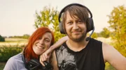 Anja und Andreas mit Controllern und Headsets in ihrem Garten.