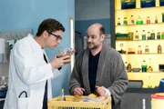 Elias (Stefan Ruppe, l.) sucht nach der Ursache für Bents (Christoph Tomanek, r.) vermeintliche Fleischvergiftung; er scheint fündig geworden zu sein.