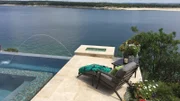 The Pool Kings designed a small patio for lounging and overlooking the lake, the pool, and the spa.