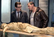 Finn Kiesewetter (Sven Martinek, r.) und Lars Englen (Ingo Naujoks, l.) stehen vor einem Rätsel. Welches Motiv hatte der Täter, die Geschäftsführerin einer Lackfabrik (Antonia Gerke, v.) zu töten und mit goldener Farbe zu besprühen?