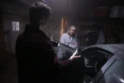 LS Actor Duane (Thomas John Murphy) holding flashlight to camera found in car/ Actor Dana (Kathleen Dobbs) looking concerned