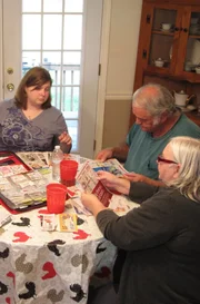 Amanda clips coupons with her husband and parents.
