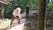 Marty cutting metal sheet with a chainsaw, Lou watching