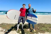 André Gatzke (l) lernt Surfen mit Manolis Orphanos.