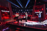Moderator Jörg Pilawa (r.) mit den Kandidat:innen des Teams "Schlager": Schlagersänger Matthias Reim (l.) mit Ehefrau Christin Stark (2.v.l.), Schlagersängerin. Sowie dem Quizexperten Eckard Freise (M.).