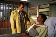 Dr. Gregory House (Hugh Laurie, l.) untersucht den bekannten Baseballspieler Hank Wiggen (Scott Foley, r.), der sich bei einem einfachen Wurf den Arm gebrochen hat.
