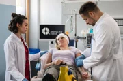 Die Untersuchung von Nadine Bütow (Tina Schorcht, M.) wird zur Herausforderung für Rebecca (Milena Straube, l.) und Matteo (Mike Adler, r.), denn die Patientin leidet an Berührungsangst.