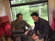 Rob and Stefan review data as they ride a train across the Polish countryside.