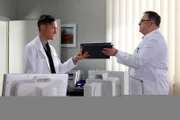 Dr. Kaminski (Udo Schenk, links) bittet Hans-Peter Brenner (Michael Trischan) die Voruntersuchung einer Patientin zu übernehmen. Die erste Freude über Kaminskis entgegengebrachtes Vertrauen, lässt bei dem angehenden Arzt Hans-Peter allerdings schnell wieder nach, als Kaminski hinterherschießt, dass man bei dieser Untersuchung eh nichts falsch machen kann.