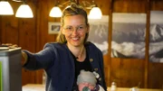 Hüttenwirtin der Reintalangerhütte im Gastraum mit Baby.