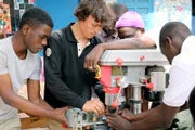 Bei seinem Zwischenstopp in Dakar besucht Corentin (Mi.) auch das Recycling-Paradies im Stadtviertel Colobane und erfährt, wie Wind zur Stromerzeugung dienen und somit die Bewässerungspumpe auf dem Katamaran antreiben kann.