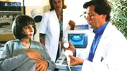 Dr. Stefan Frank (Sigmar Solbach) untersucht seine hochschwangere Patientin Dr. Ursula Ronacher (Michaela May, li.). Carmen (Sophie Schütt, hi.) assistiert ihm.