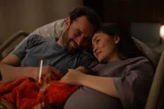Caro (Mai Duong Kieu, r.) und ihr Freund Vincent (Axel Benrath, l.) haben es geschafft: Ihr erstes gemeinsames Kind ist zur Welt gekommen, und darauf stoßen sie an.
