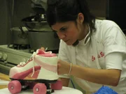 Dragon Cake and Roller Skate Cake. Toni Walton adds detail to a roller skate cake for Buddy's niece.