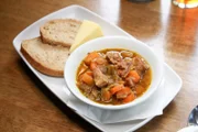 In Cardiff wird „Cawl“, ein traditioneller walisischer Eintopf bestehend aus Fleisch und Gemüse, mit Schwarzbrot und einem Stück festen, cremigen walisischen Käse serviert.