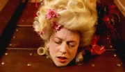 Simone de Lille (Louise Linton), die zur Kostümparty als Marie Antoinette erschien, liegt tot unter der Guillotine. Allerdings starb sie nicht durch das Fallbeil!