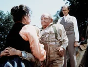 Harriet (Katherine MacGregor, l.) und Nels Oleson (Richard Bull, r.) sind Lou Bates (Billy Barty, M.) für die Rettung ihrer Tochter dankbar.