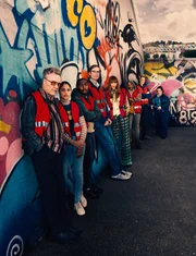 (v.l.n.r.) Frank Sheldon (Christopher Walken); Rani Rekowski (Rhianne Barreto); Christian Taylor (Gamba Cole); Gregory Dillard (Stephen Merchant); Lady Gabriella Penrose-Howe (Eleanor Tomlinson); Myrna Okeke (Clare Perkins); John Halloran (Darren Boyd); Diane Pemberley (Jessica Gunning)