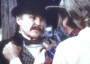 Edwards (Victor French, M.) und Almanzo (Dean Butler, r.) wollen von Dr. McQueen (Anthony Zerbe, l.) wissen, warum er den jungen Matthew wie ein Tier in einem Käfig hält.