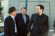 Mike begrüßt die Lansinger bei seiner Werkstattparty. Von links: Bürgermeister Schattenhofer (Werner Rom), Pfarrer Neuner (Peter Rappenglück) und Mike Preissinger (Harry Blank).