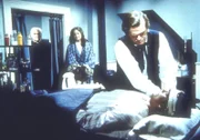Dr. Baker (Kevin Hagen, r.) versorgt den verletzten John Carter (Stan Ivar, l.). Carters Frau Sarah (Pamela Roylance, M.) sieht besorgt zu.