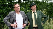 Mit skeptischen Blicken verfolgen Friseur Jürgen Seute (Dirk Martens, li.) und Dorfpolizist Peter (Uwe Rohde, re.) das Geschehen.
