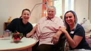 Checkerin Marina (links) besucht eine Mitbewohnerin im Altenheim und unterstützt die Pflegerin bei ihrer Arbeit.