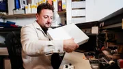 Ein Mitarbeiter des Pfandleihers überprüft die Xbox