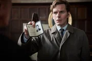 Endeavour Morse (Shaun Evans) befragt einen Kunsthändler und zeigt diesem seinen Dienstausweis vor.