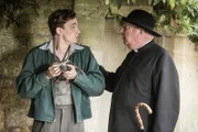 Lewis Ward (Thomas Pickles, l.) liebt es zu fotografieren. Als er einen schlafenden Mann ohne sein Wissen ablichtet, hält Father Brown (Mark Williams, r.) ihn auf. Welche seltsamen Eigenschaften verbirgt der geheimnisvolle Junge außerdem noch?