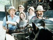 Almanzo (Dean Butler, l.) und Laura (Melissa Gilbert, 2.v.l.) verteidigen gemeinsam mit Mr. Edwards (Victor French, r.) die Farm von John (Stan Ivar) und Sarah Carter (Pamela Roylance).