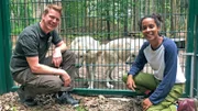 Pia und Frank Faß, Leiter des Wolfcenters Dörverden, vor dem Wolfsgehege. Frank hat die Geschwisterwölfe Cosmo und Luna von Hand aufgezogen.