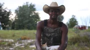 Kennard smiling with a kitten on his lap