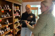 Judith Wannagat (rechts) vom Gut Steinwehr klärt im Hofladen Mitarbeiterin Hanna über die unbekannte Aronia-Beere auf, aus der Gelee gemacht wird.