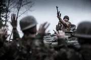 Leutnant Tony Ward feuert ein Maschinengewehr in die Luft, um die Deutschen zur Kapitulation zu zwingen. Tanner Gillespie.