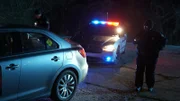 Police officers checking out abandoned pizza delivery car