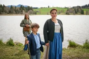 Simone Schuster (Muriel Baumeister, r.) nimmt ihren Pflegesohn Jakob (Valentin Thatenhorst, M.) an die Hand und zieht ihn von seiner leiblichen Mutter Tamara Berger (Lo Rivera, l.) weg, die Jakob an den See gefolgt ist.