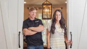 Hosts Chip and Joanna Gaines stand at the sliding doors to Ermoian's newly remodeled office, as seen on Fixer Upper.
