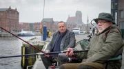 Jan-Hinrich Reuter (Udo Kroschwald, l.) nutzt seine jahrzehntelangen Freundschaften in und um Wismar, um in der Frage nach einer seltenen finnischen Waffe die richtigen Antworten zu finden. Sein Anglerfreund Horst Vierkötter (Herbert Olschok, r.) kennt sich als Vorsitzender des Schützenvereins natürlich bestens aus. Doch kann er den Ermittlern schlussendlich den entscheidenden Hinweis geben, der die Kommissare auf die Spur des Täters führt?