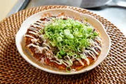 Okonomiyaki sind eine Art Pfannkuchen, die traditionell auf dem Teppan, der japanischen heißen Eisenplatte zubereitet werden.