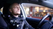 Polizist im Auto.