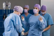Nachdem Dr. Koshka (Katharina Nesytowa, 2.v.r. mit Komparsen) ihre Blinddarmpatientin Antonia Lindeman bewusstlos und mit offener OP-Wunde auffindet, bringt sie diese sofort in den OP. Da kein Oberarzt im Haus ist, muss sie auf Prof. Patzelt warten.