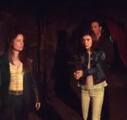 Wieder zu Hause verwandelt sich Paige nach und nach in einen Vampir. Phoebe (Alyssa Milano, M.), Cole (Julian McMahon, r.) und Piper (Holly Marie Combs, l.) suchen fieberhaft nach einem Gegenzauber.