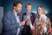 Die exzentrische Modezarin Helene Huck (Gudrun Gundelach, r.) lässt sich ihre Lebensfreude nicht nehmen und stößt im EKH mit ihrem Freund René (Falk-Willy Wild) und ihrer Haushälterin Elfie (Katharina Blaschke, M.) auf die Liebe, das Leben und die Freiheit an.