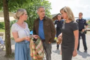 Die Kommissare Bergmann (Florian Fitz, M.) und Danner (Katharina Abt, r.) konfrontieren Sonja Amann (Claudia Hinterecker, l.) damit, dass ihr Dirndltuch möglicherweise die Tatwaffe sein könnte. (Im Hintergrund: Komparsen).