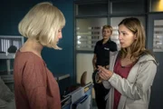 Melanie (Sanna Englund, M.) bringt Simone Meckel (Astrid Leberti, r.) zu Ina Wieland (Kristina Pauls, l.). Simone will herausfinden, was Ina Wieland mit ihrem Mann verbindet.