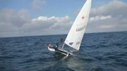 Sailor and sailboat topple over.