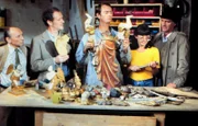 Annette von Soettingen hat vom "Tierparktoni" einen geschnitzten Heiligen Florian erworben. Der Toni ist kein Heiliger und die Statue nur teilweise. (Karl Obermayr als Manni Kopfeck, 2. v.links, und Helmut Fischer als Monaco Franze, rechts mit Hut).