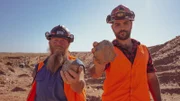 James 'JC' Caruana and Rod Manning holding up a garnet to the camera in a garnet mine.